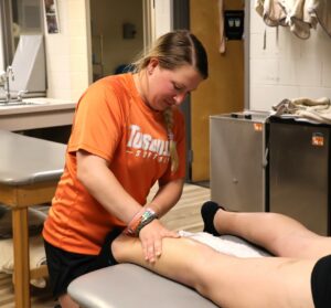 McKinlay Bryant, assistant athletic trainer at Tusculum, helps prepare softball player Claire Smeltzer for her next game.