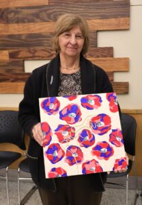 Pauline Adams shows the painting she won at the silent auction.