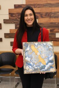 Heather Carbajal holds the painting she won at the silent auction.