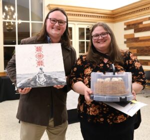 Ben Gilliam, left, holds the painting, and Lisa Chiapputo holds the cake they won during the event.