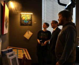 Left to right, Tusculum student Isabella Gall; Dr. Scott Hummel, Tusculum’s president; and Tusculum student Caleb Brown look at one of the paintings being auctioned.