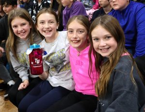 Classmates pose with one of the prize winners at the game.