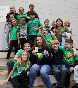 Teacher Cheyene Burrow, who won a prize, is surrounded by students.