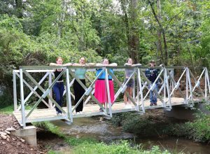 Tusculum University students stand on the new bridge. They are, left to right, Sage Clapp, Kyra Klouzek, Mirissa Walters, AnnaLee Simpson and Rusty Thompson.