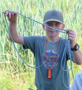 A camper shows a knot he made at Pioneer Skills Camp.