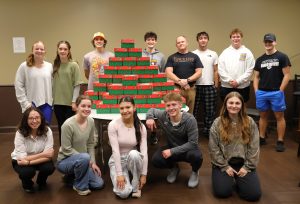 Students who reside in the Discipleship Living-Learning Center stand by the shoeboxes they helped stock in support of Operation Christmas Child.