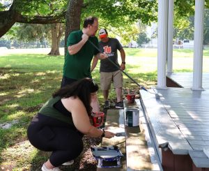 Katie Odoms, foreground, and Dr. David Cook paint at the male house of the Discipleship Living-Learning Center.