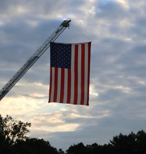 The Tusculum Fire Department hoists an American flag outside Eastman Credit Union Field at Pioneer Park.