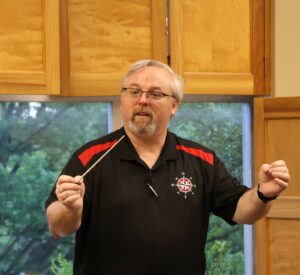 Chris Chambers conducts the band.
