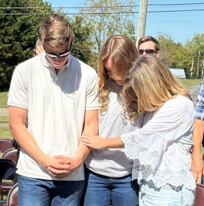Left to right, Jonathan Bowlin, Amelia Larson and Tammy Bowlin pray during the event.