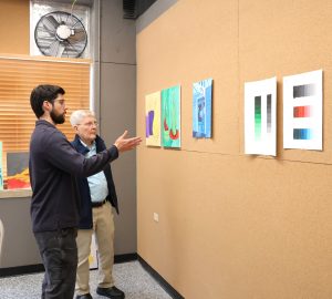Benjamin Conley, left, shows Clem Allison the corkboard in the two-dimensional studio art laboratory.