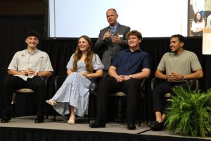 The Rev. E.J. Swatsell, standing, leads the panel discussion with, left to right, Rio Little, Danielle Dugger, Noah Brown and Nour Nabi.