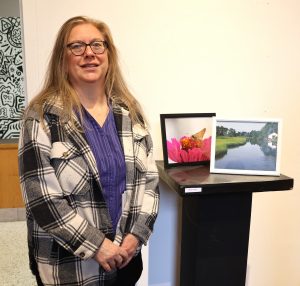 Staff member Betsy Long stands by her photographs, which are included in the show.