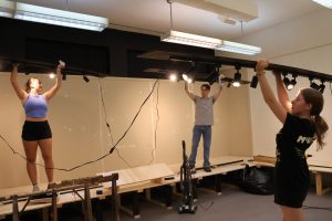 Left to right, students Kyra Klouzek, Rusty Thompson and AnnaLee Simpson are about to place a new lighting track in the exhibit room.