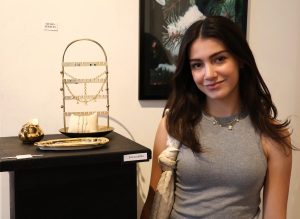 Student Sienna Laffitte stands with jewelry she developed.
