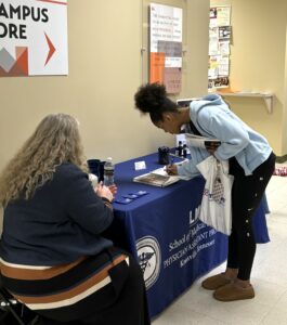 Tusculum student Taylor Sanders, right, visits the Lincoln Memorial University physician assistant program booth. Photo by Tusculum student Landry Tea