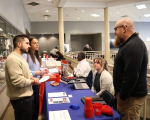 Alexis Coelho, left, and Nara Santos speak with a vendor.