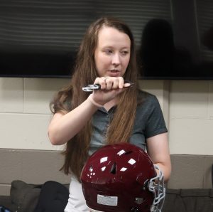 Dr. Emily Davis discusses the removal of a helmet with first responders at the Bristol Fire Department.
