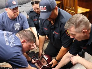 Members of the Bristol Fire Department remove a helmet from one of their colleagues during a practice session.