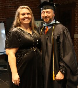 Ross Frizzell, right, and his wife, Erin, celebrate after he graduated with his master’s degree.