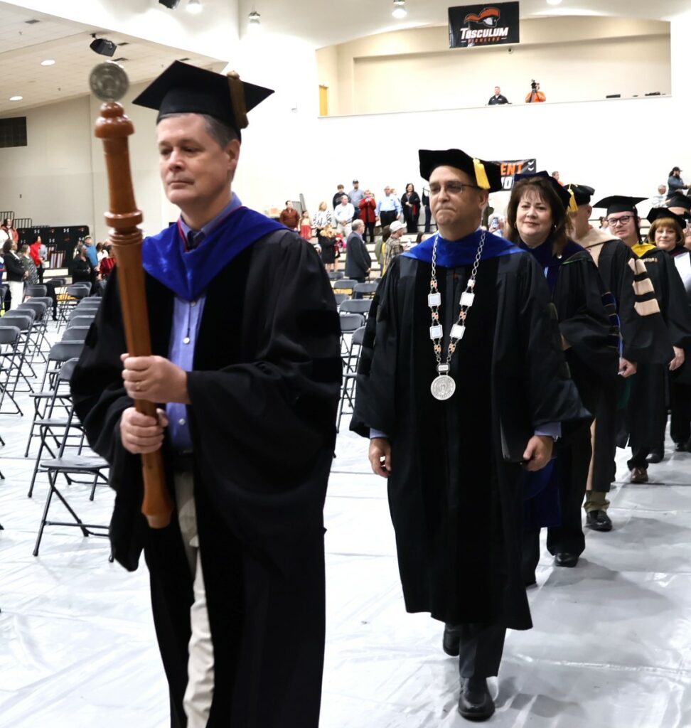 Dr. Joel Van Amberg, faculty chair, leads the process into the 12-9-23 graduation ceremony.