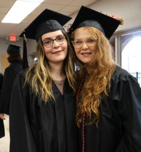 Stacie Bergquist, right, and her daughter, Alexandra, enjoy a moment together before the start of graduation.