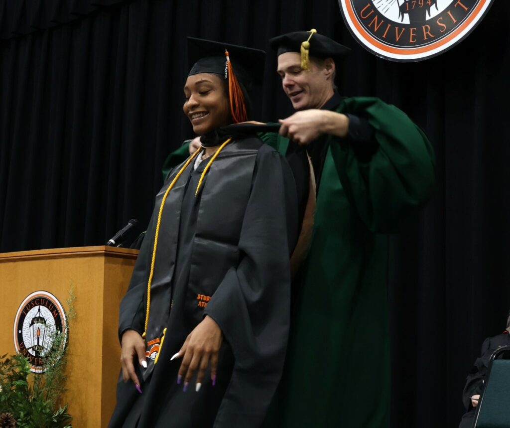 Dr. Kevin Hill, right, hoods a graduate at the 12-9-23 graduation ceremony.