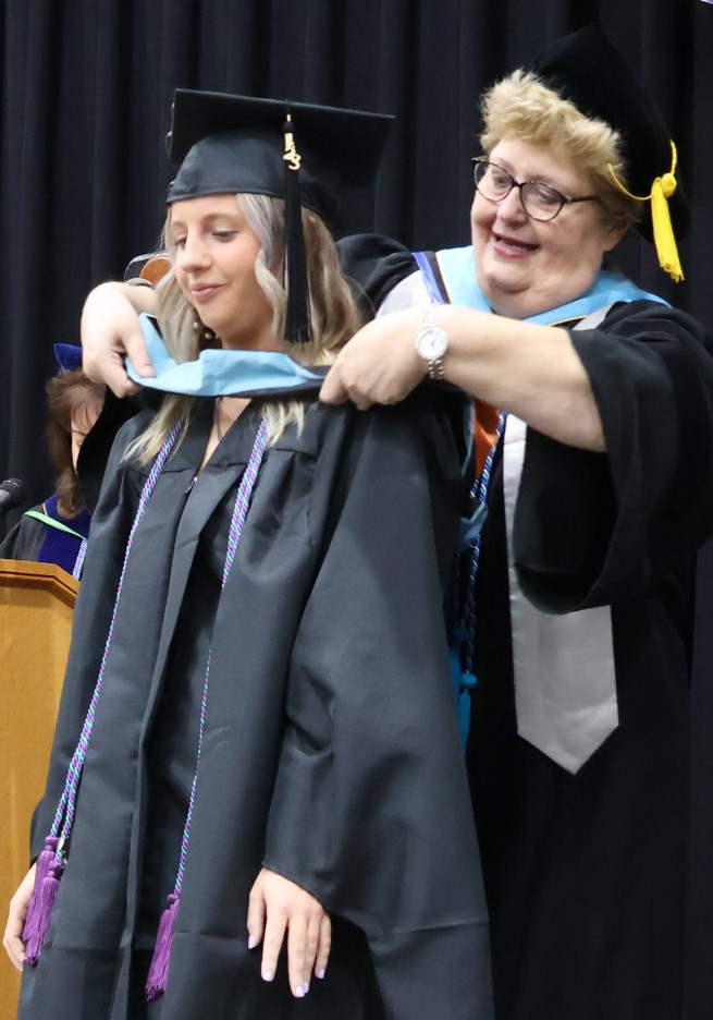 Dr. Peggy Goodson-Rochelle, right, hoods a Master of Arts in Teaching graduate on 12-9-23.