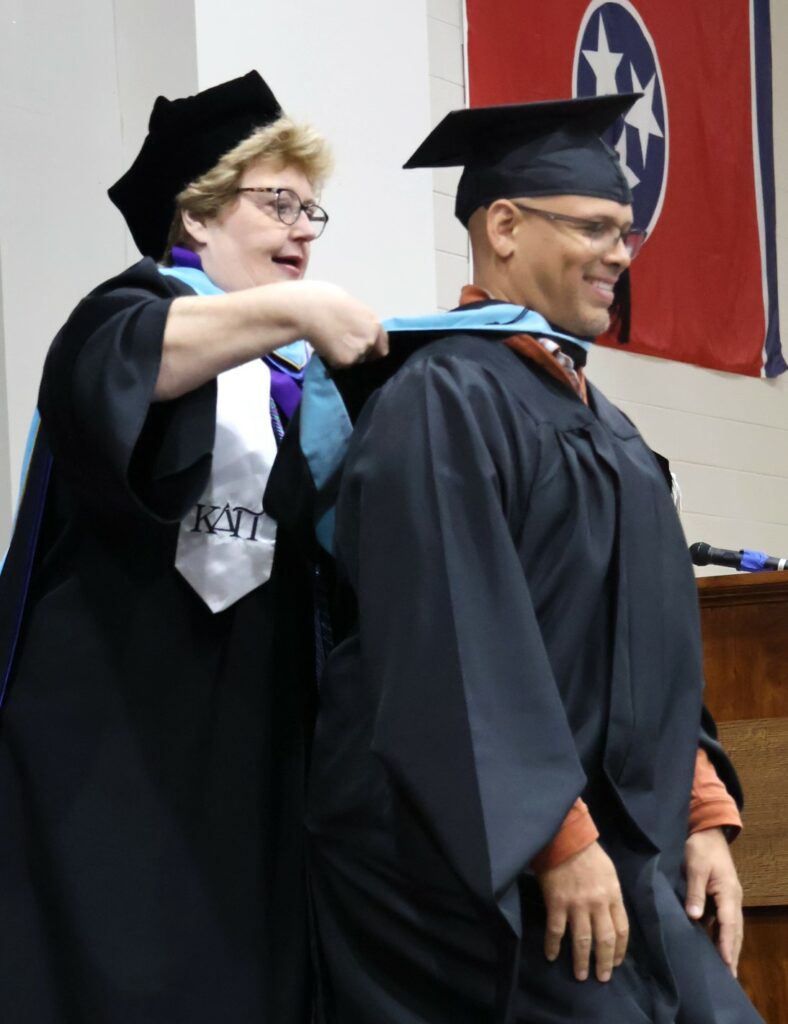 Dr. Peggy Goodson-Rochelle hoods a Master of Arts in Teaching graduate on 12-9-23.