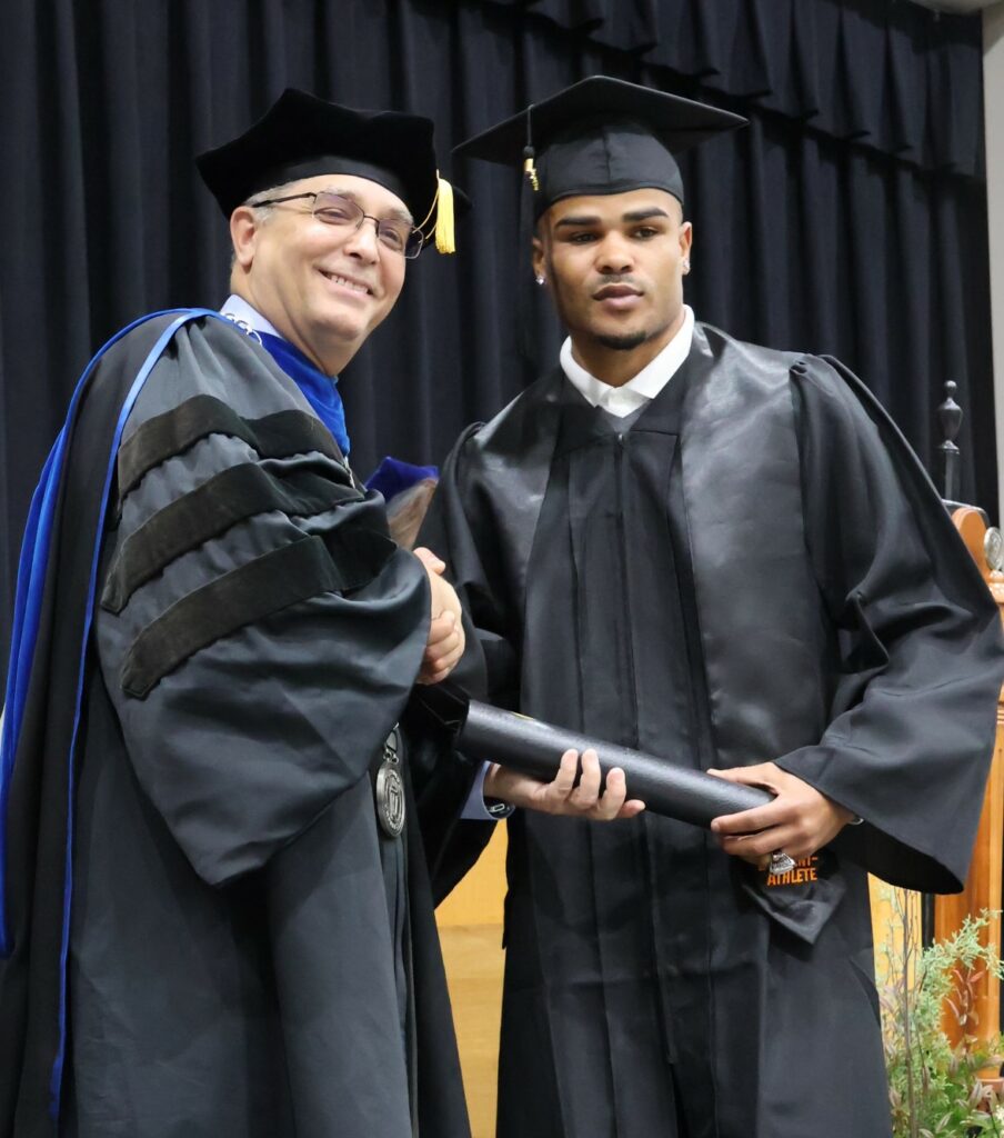 Dr. Scott Hummel, left, congratulates a graduate on 12-9-23.
