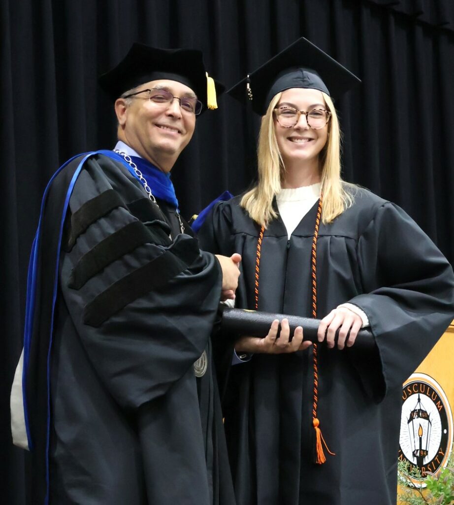 Dr. Scott Hummel, left, congratulates a graduate on 12-9-23.