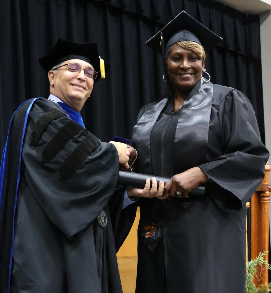 Dr. Scott Hummel, left, congratulates a graduate on 12-9-23.