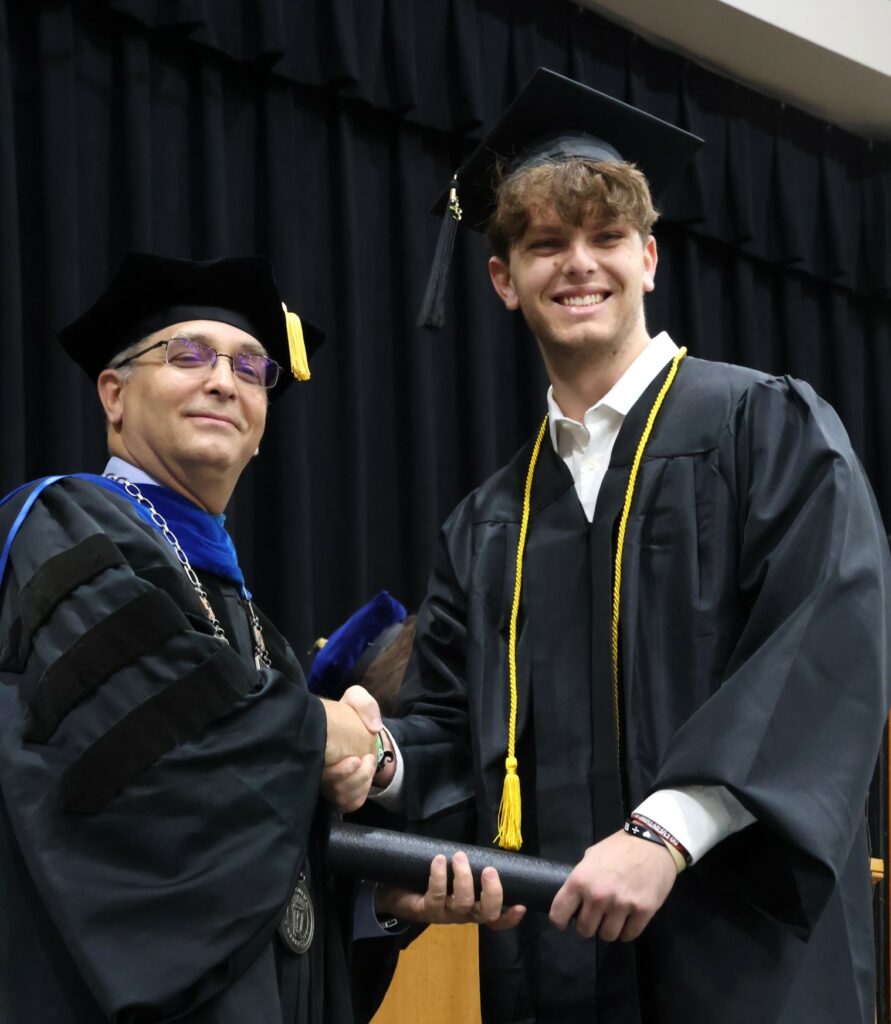 Dr. Scott Hummel, left, congratulates a graduate on 12-9-23.