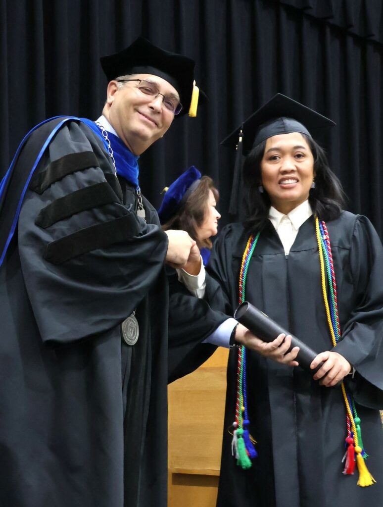 Dr. Scott Hummel, left, congratulates a graduate on 12-9-23.