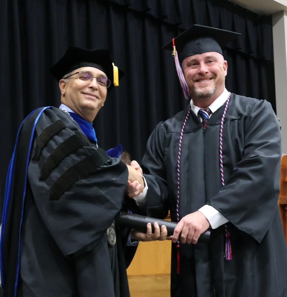 Dr. Scott Hummel, left, congratulates a graduate on 12-9-23.