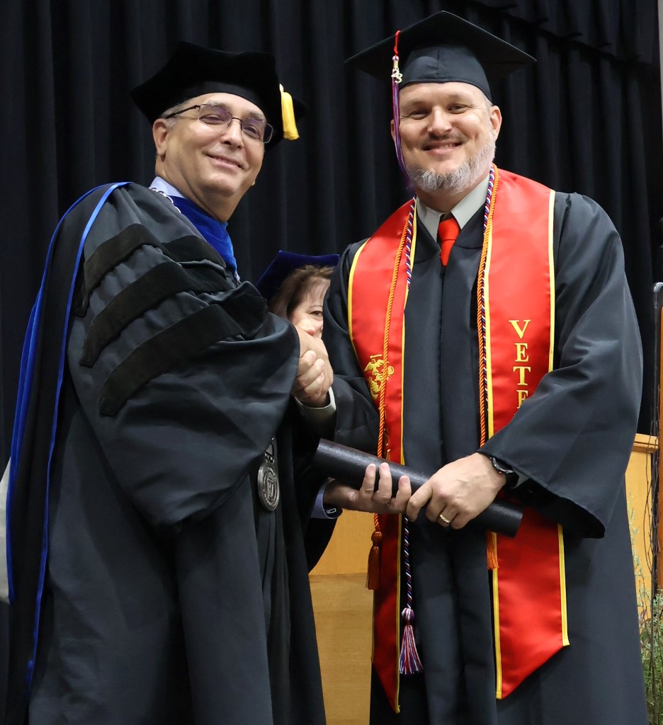 Dr. Scott Hummel, left, congratulates a graduate on 12-9-23.