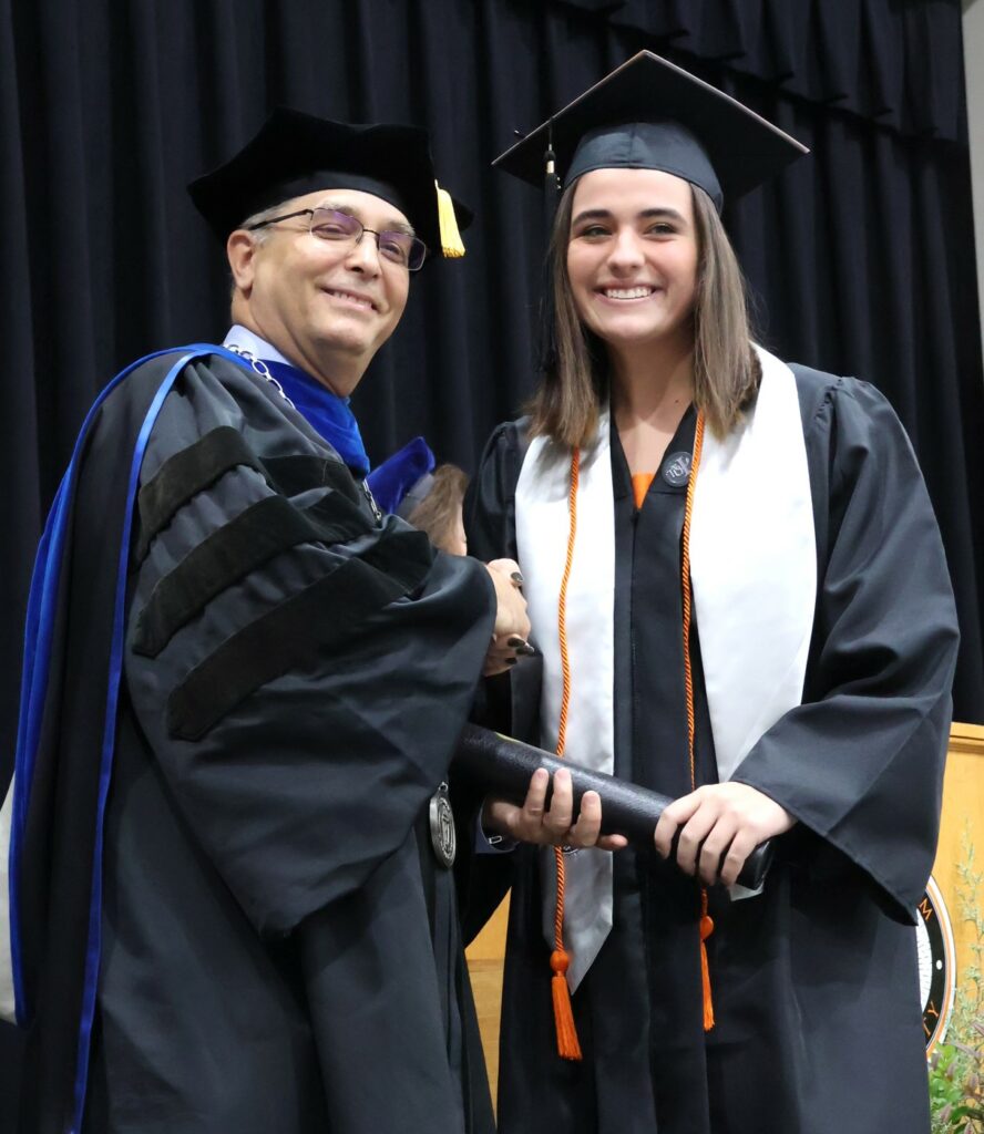 Dr. Scott Hummel, left, congratulates graduate Ashley Forbes on 12-9-23.