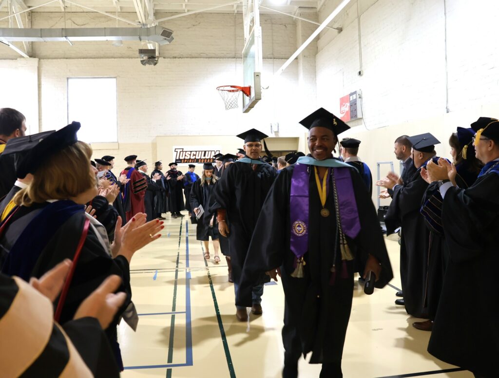 Faculty and administrators clap for graduates after the 12-9-23 graduation ceremony.