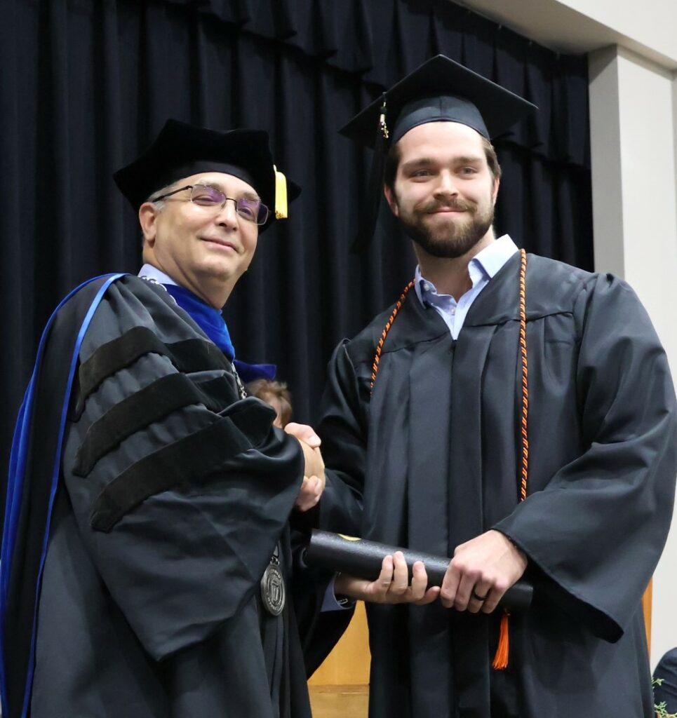 Dr. Hummel congratulates a graduate.