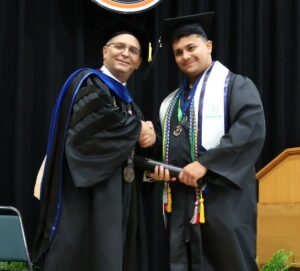 Dr. Scott Hummel, left, congratulates a graduate.