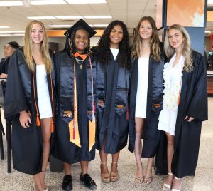 A group of students enjoys a moment before the start of graduation.
