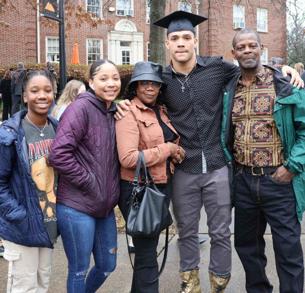 A graduate and his family gather for a photo.