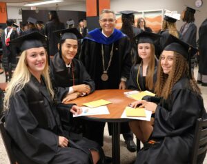 Dr. Scott Hummel, center, meets with graduates before the ceremony.