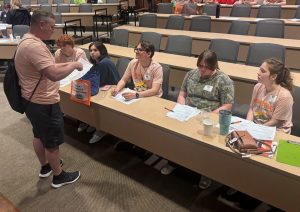 Stephen Thompson, standing, assists students with “Level Up: The Real-World Challenge Escape Game.”