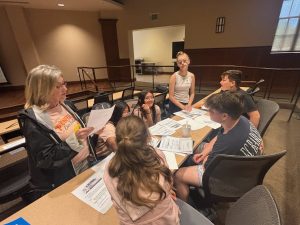 Sandi Bible, left, guides students during “Level Up: The Real-World Challenge Escape Game.”
