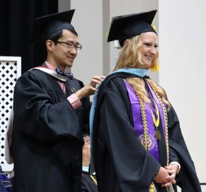 Dexter Lim, an education professor at Tusculum, hoods a Master of Arts in Education graduate.
