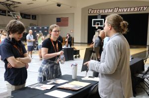 Dr. Adam Denton, right, speaks with incoming students at Pioneer Quest about the Honors Program.