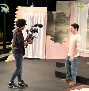 Student Todd Wallin, right, films his segment in Behan Arena Theatre on the set of “The Glass Menagerie.”