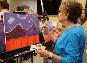 Lisa Dyer works on the painting she and her husband Jim created.