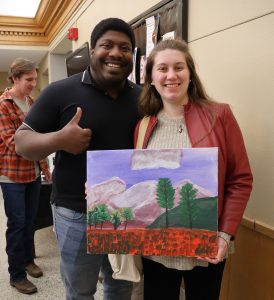 This couple shows off their completed painting.